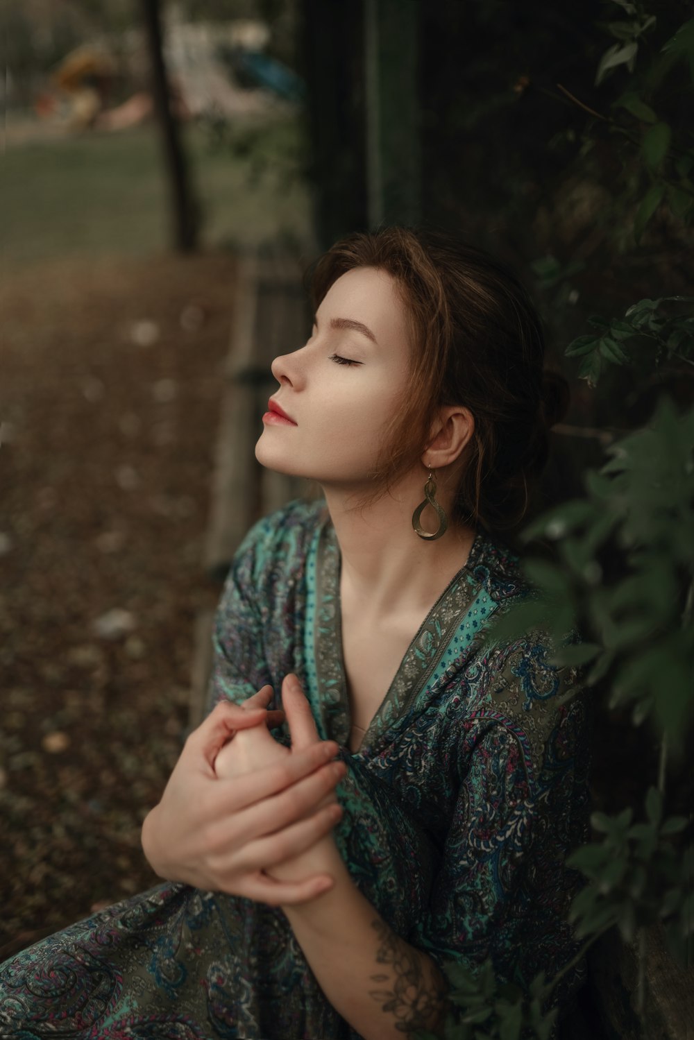 a woman sitting on a bench with her eyes closed