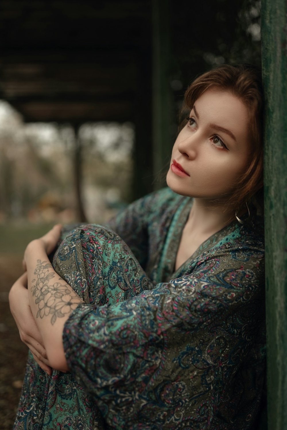 a woman leaning against a wall with her arms crossed