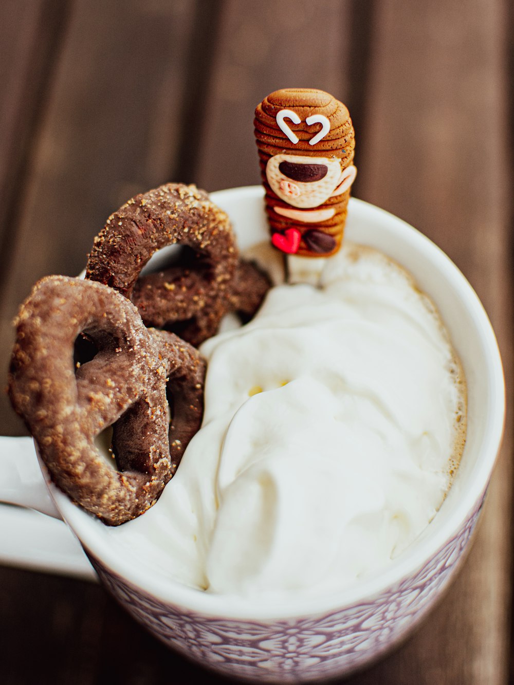 a cup filled with whipped cream and pretzels