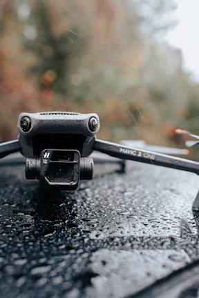 A close-up of a drone gently washing a large glass panel with water jets in action.