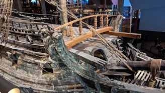 Close-up of a wooden vessel sculpture with intricate restoration details.