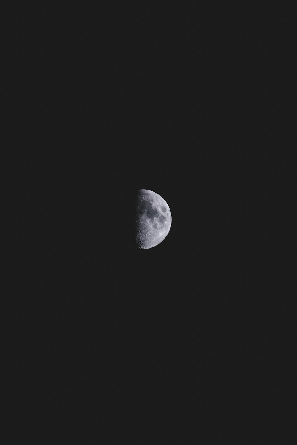 Une demi-lune est vue dans le ciel sombre