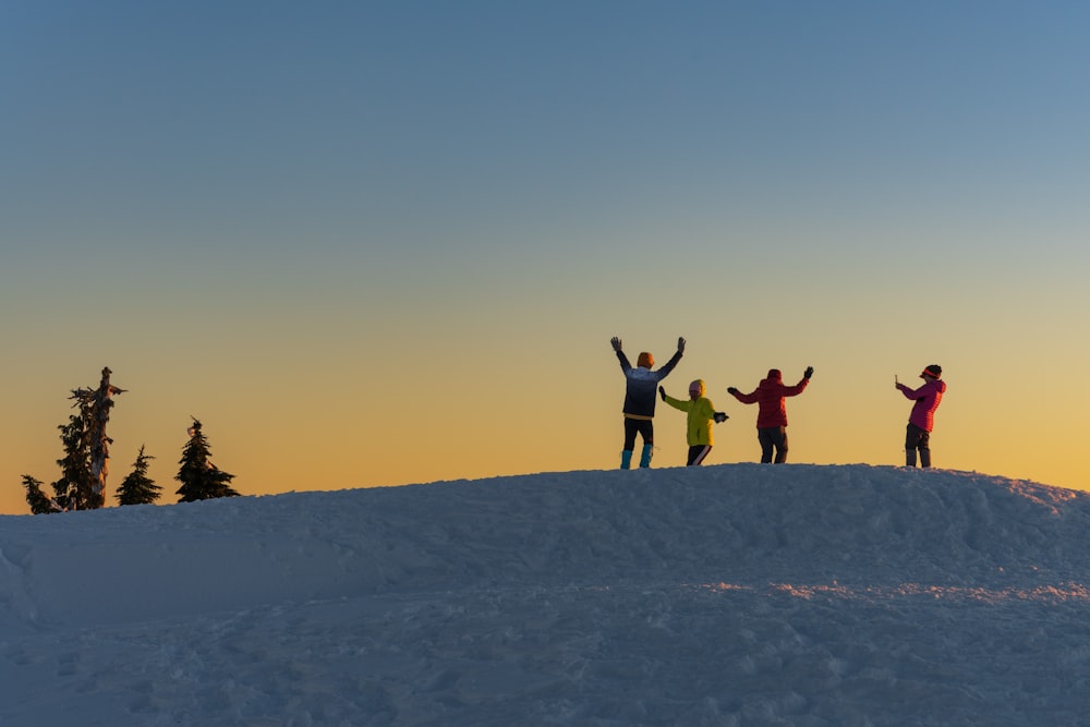 a group of people standing on top of a snow covered slope