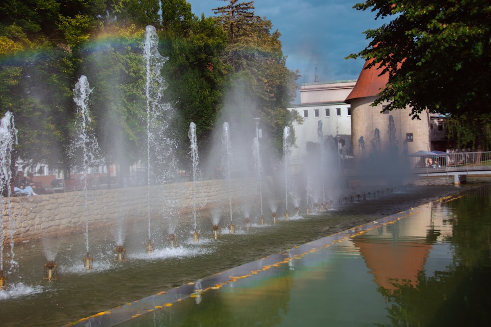 a water fountain with a rainbow in the background