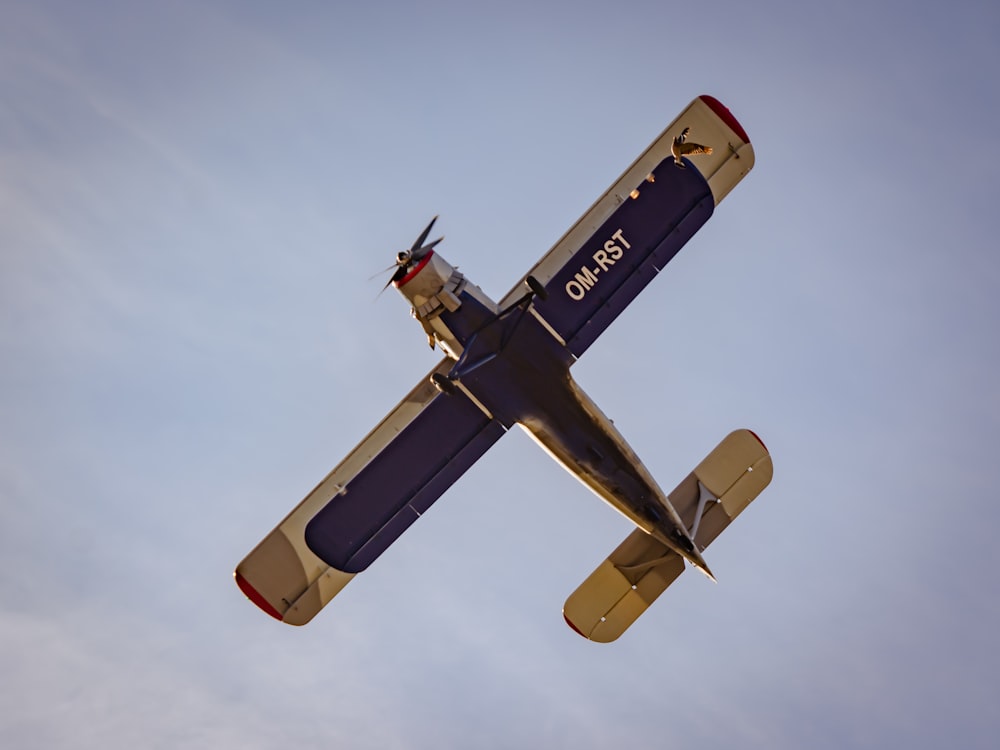 a small airplane flying through a blue sky