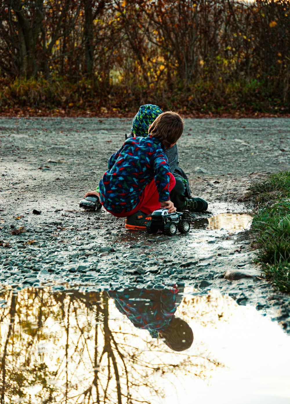 a person sitting on the ground next to a puddle