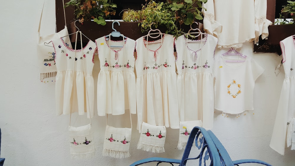 a group of white dresses hanging on a wall