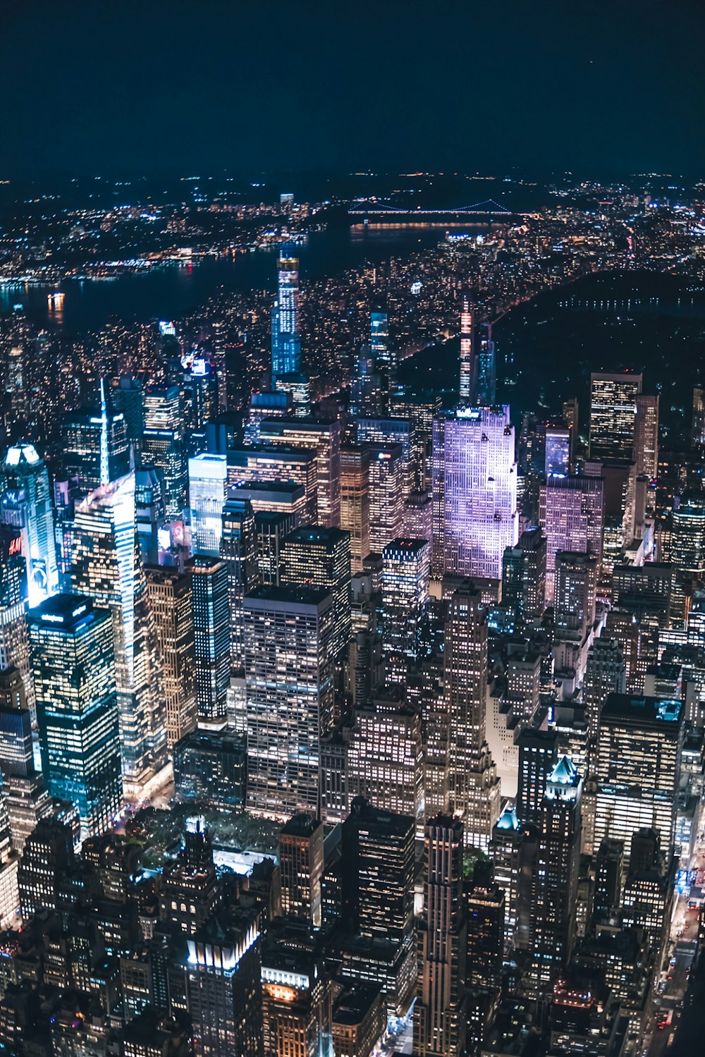 a view of a city at night from the top of a skyscraper