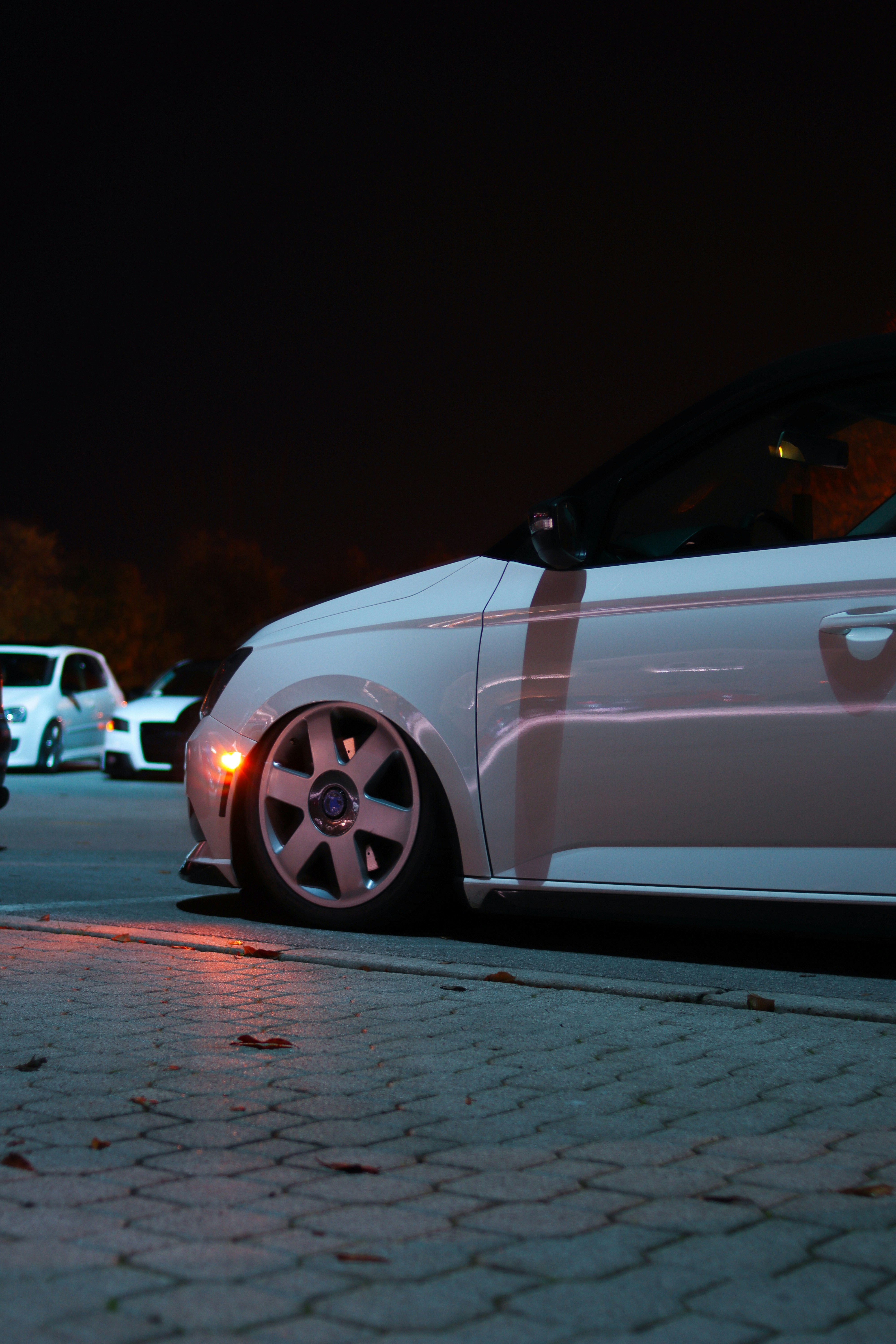a white car parked in a parking lot at night