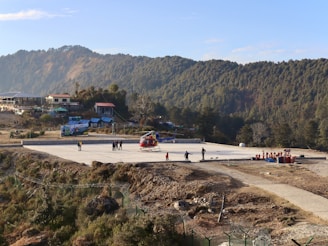 a group of people standing on top of a tarmac waiting to board helicopter for Char Dham