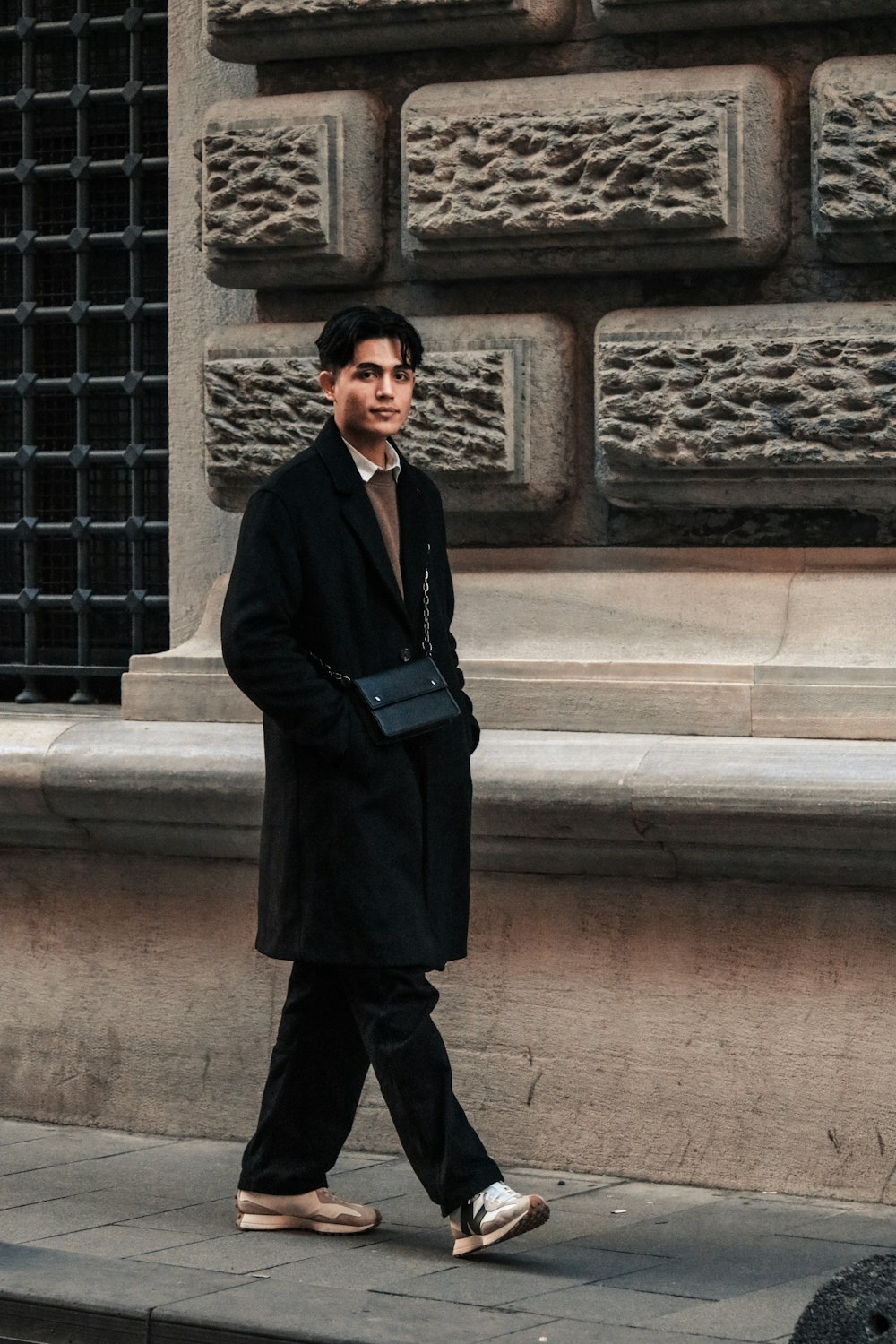 a man walking down the street in a long coat