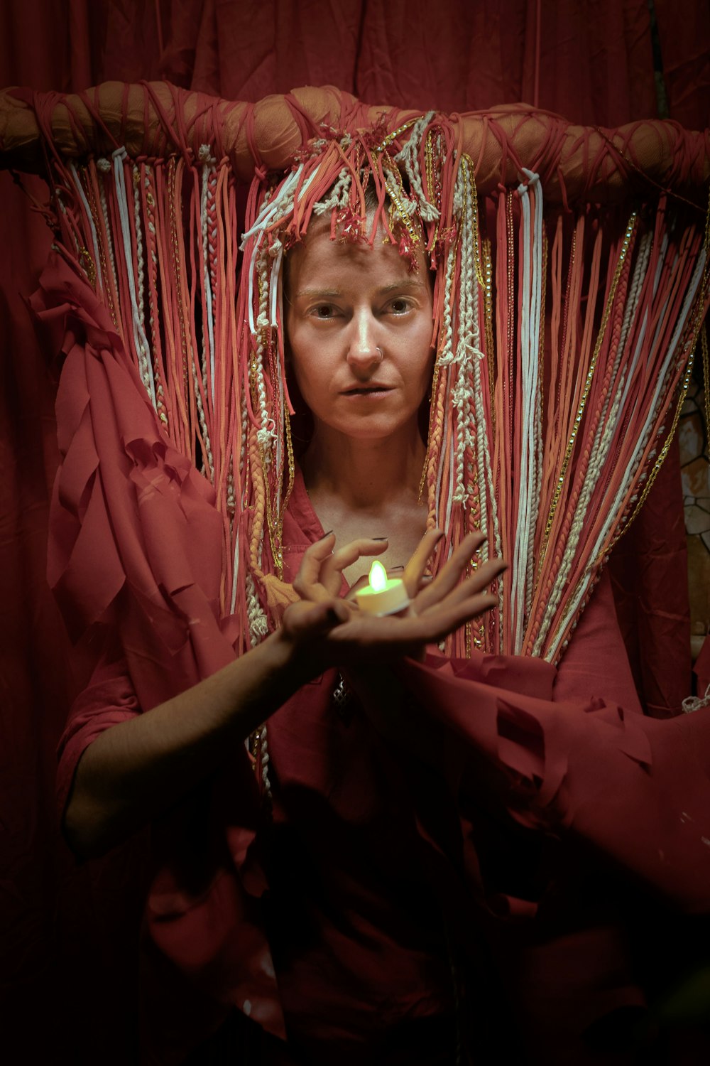 a woman in a red dress holding a lit candle