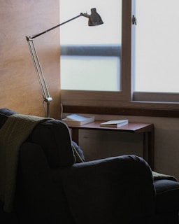 A quiet reading corner with a comfortable chair and a floor lamp.