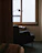 A serene therapy room with soft lighting and a comfortable chair beside a bookshelf filled with psychological books.