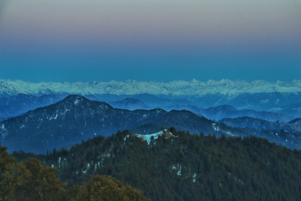 a view of a mountain range with snow capped mountains in the distance