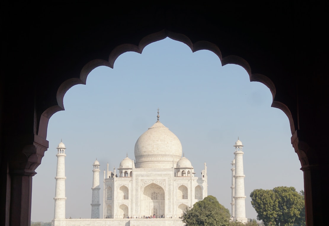 Warm sunset behind the Taj Mahal with a clear sky and no people, evoking a peaceful Indian heritage vibe.