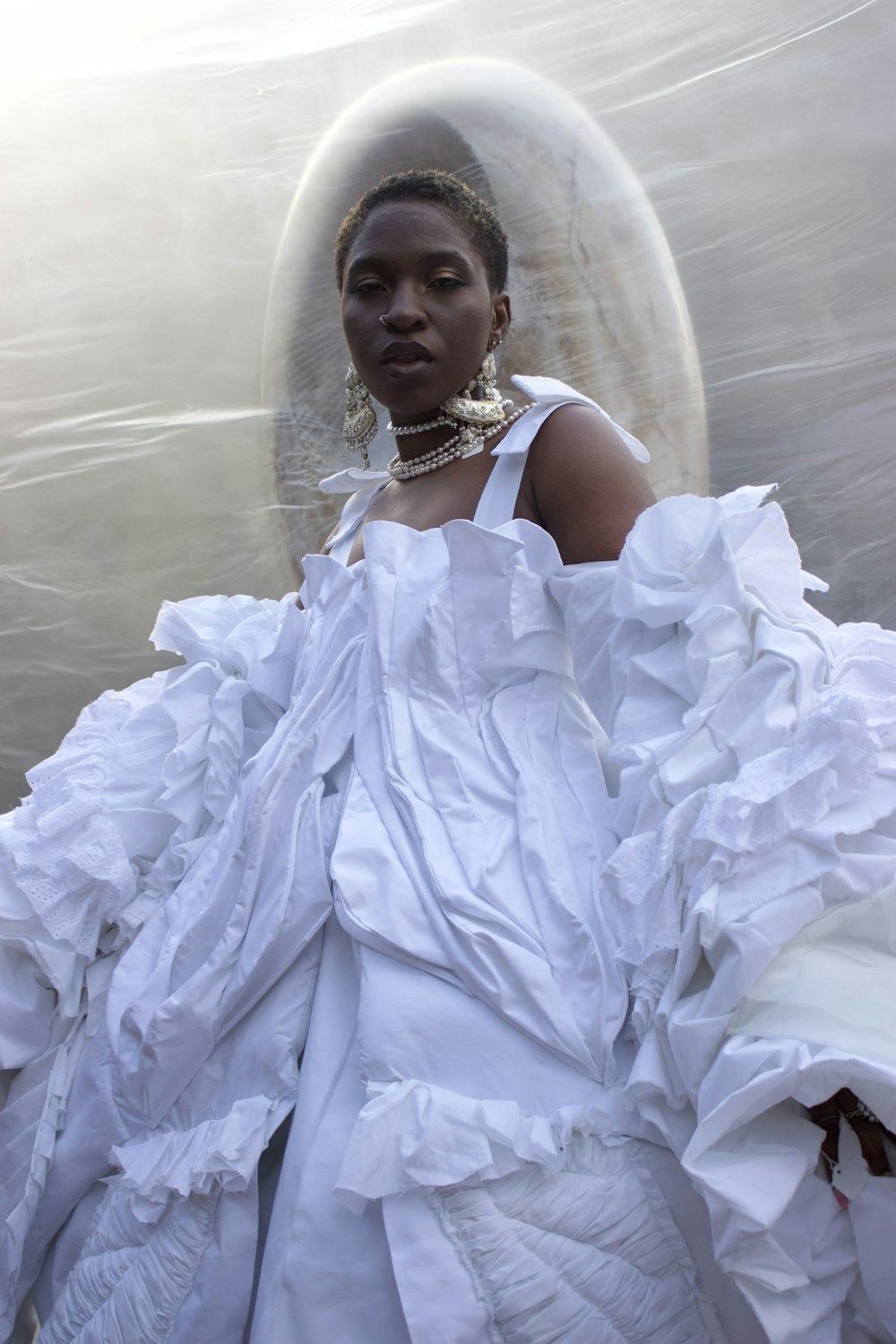 a woman in a white dress standing in front of a bubble