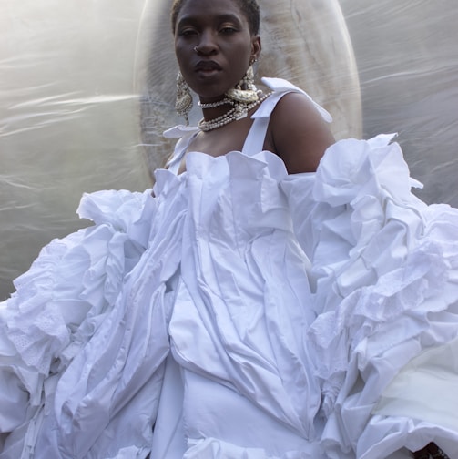 a woman in a white dress standing in front of a bubble