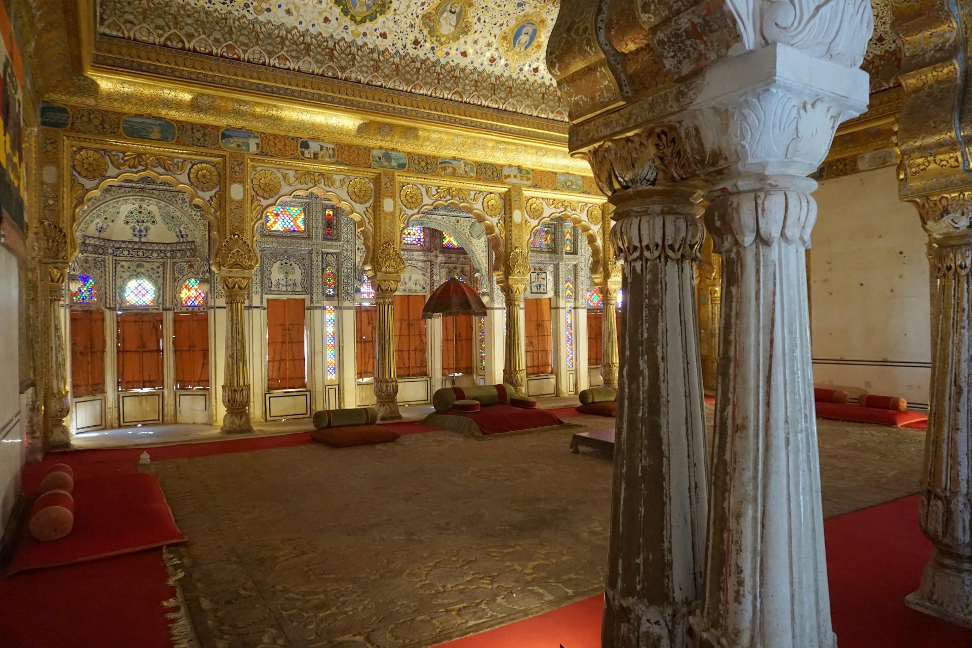 The warm, inviting interior of Raj Darbaar featuring ornate wooden carvings and rich fabrics that echo Indian royalty.