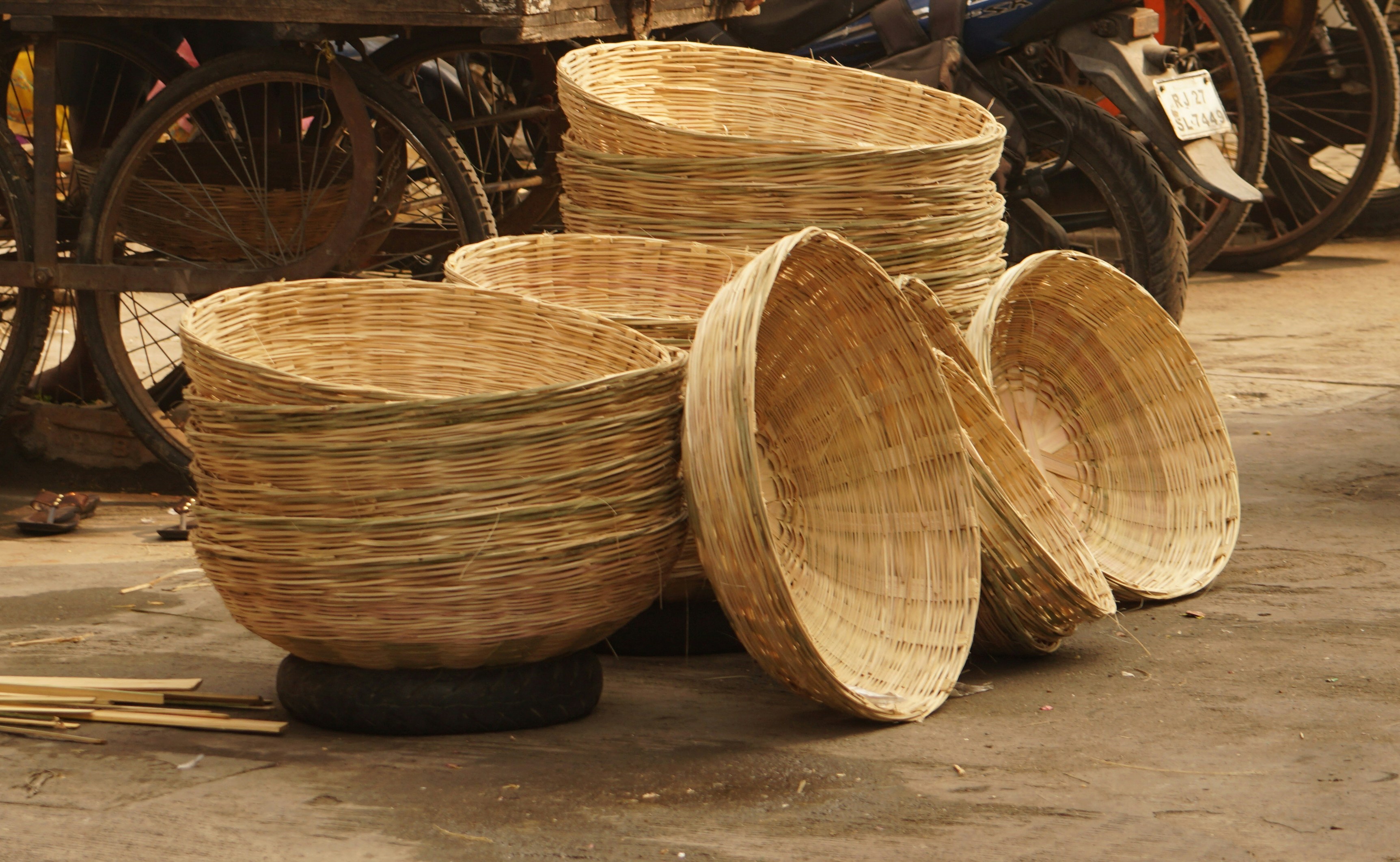 a pile of bamboo baskets sitting on top of a street