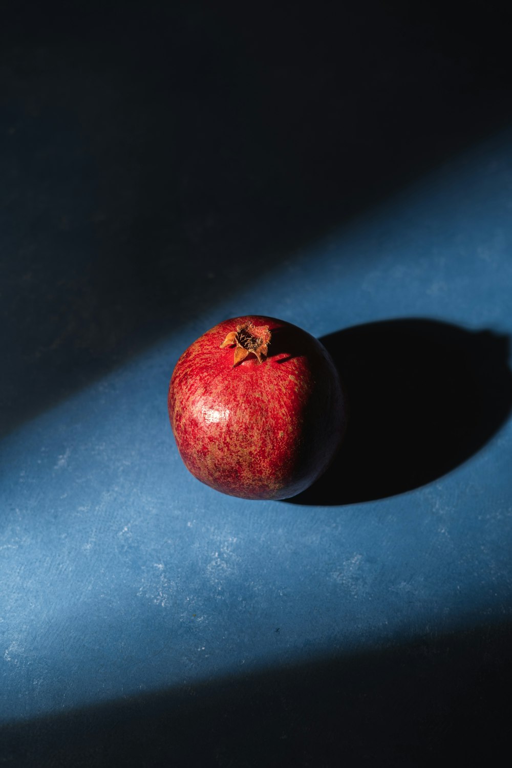 a red apple sitting on top of a blue table