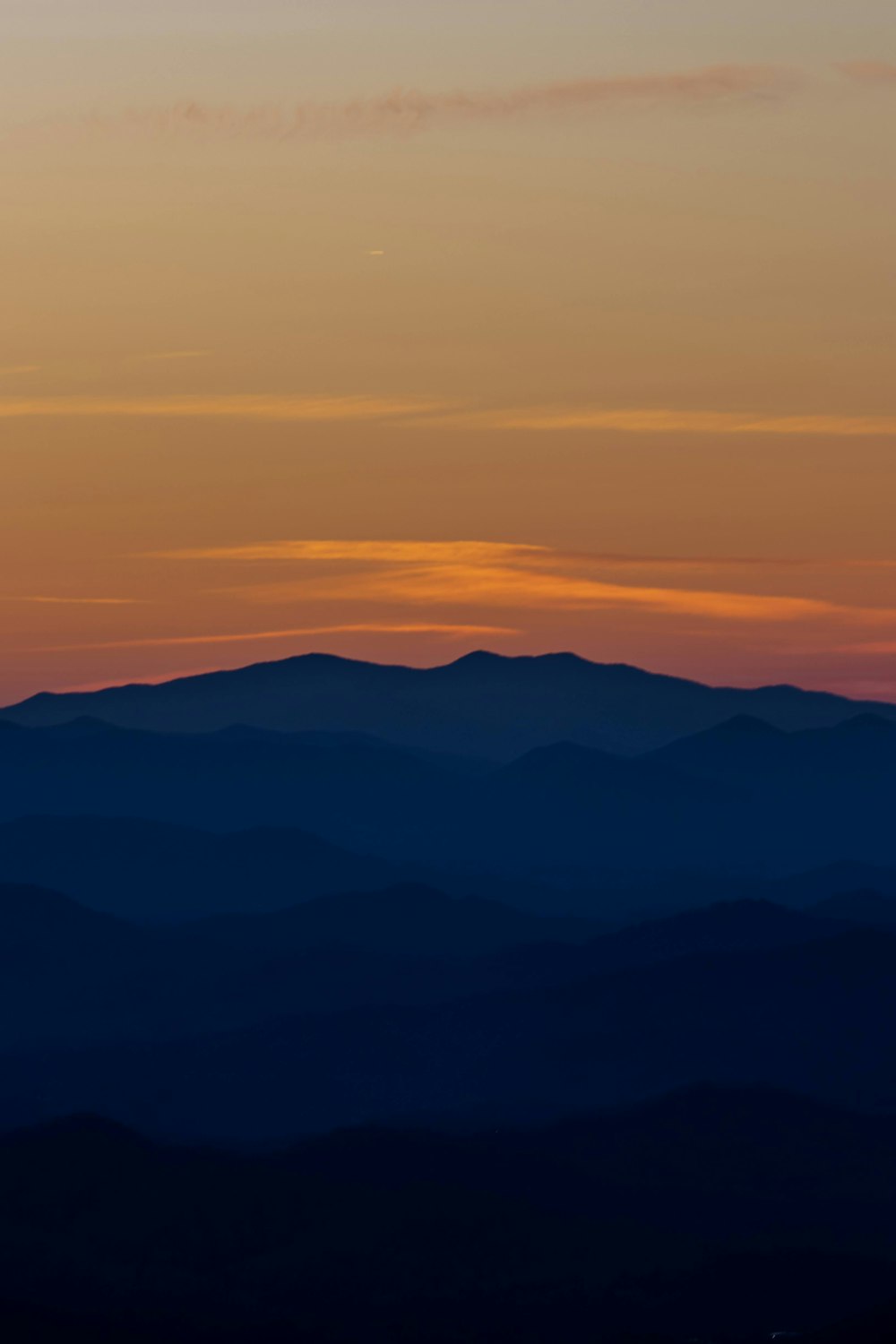 the sun is setting over the mountains in the distance