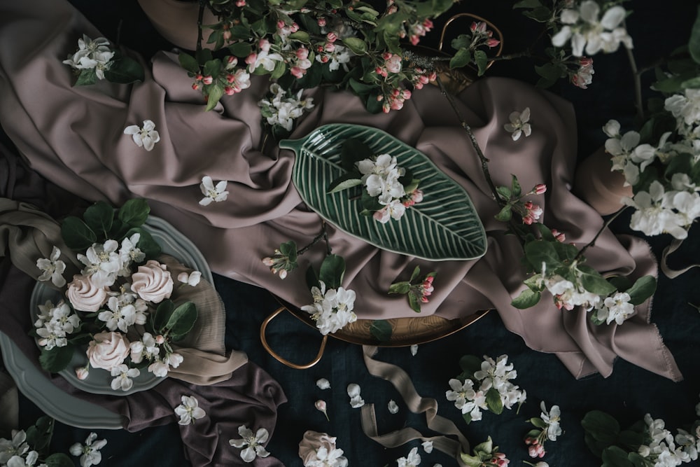 a table topped with flowers and a green leaf