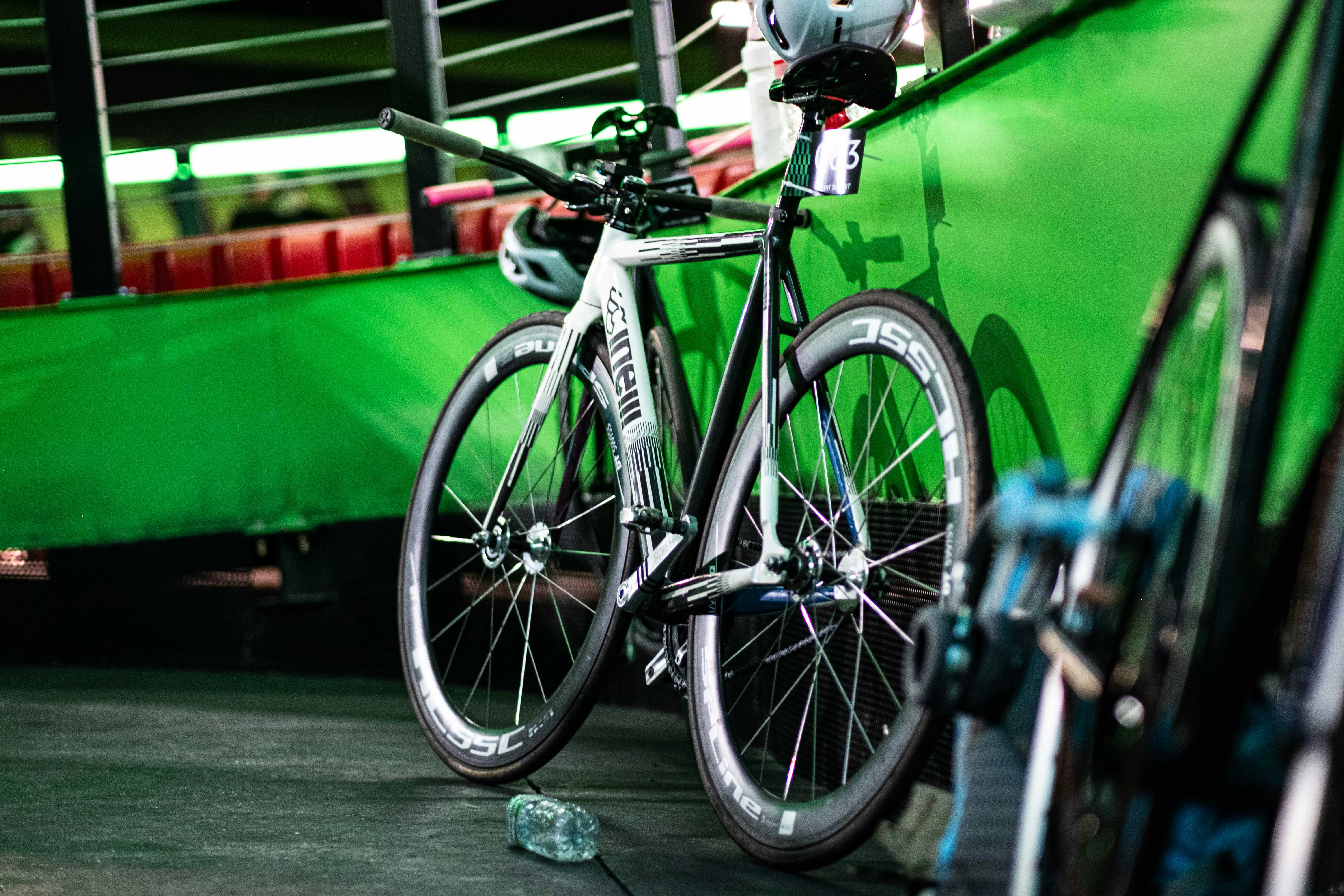 a close up of a bike parked in front of a green wall