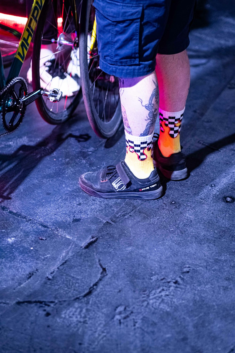 a person wearing colorful socks and socks standing next to a bike