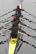 a group of people rowing a boat on a body of water