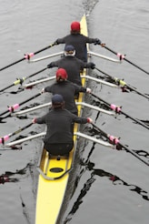 a group of people rowing a boat on a body of water