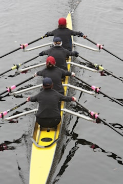 a group of people rowing a boat on a body of water