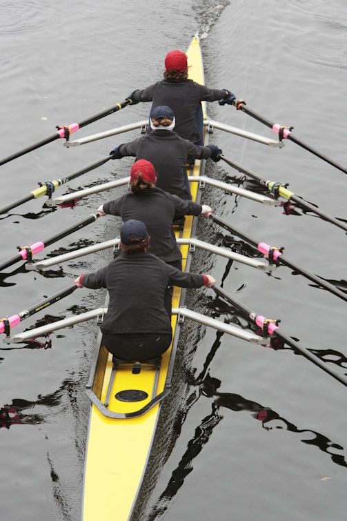 a group of people rowing a boat on a body of water