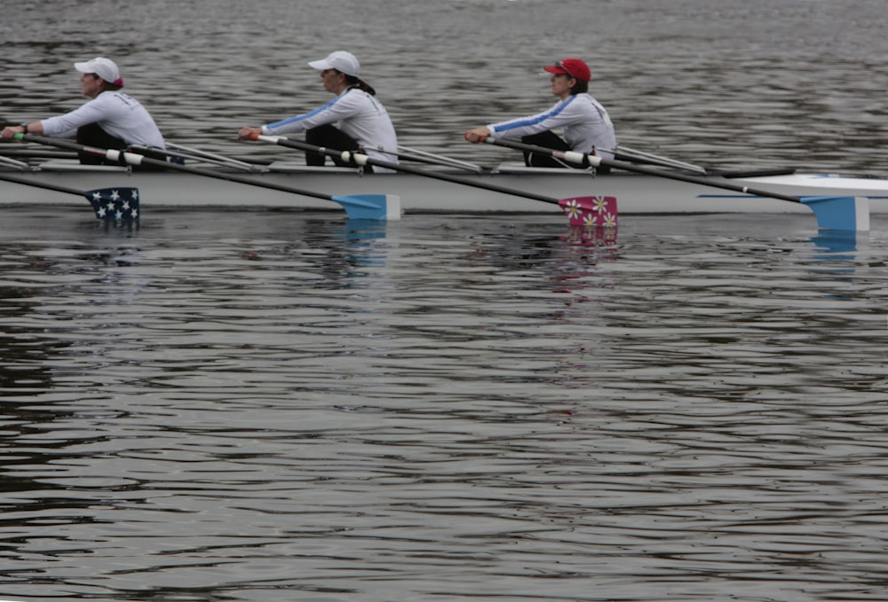 a row of rowers rowing on the water