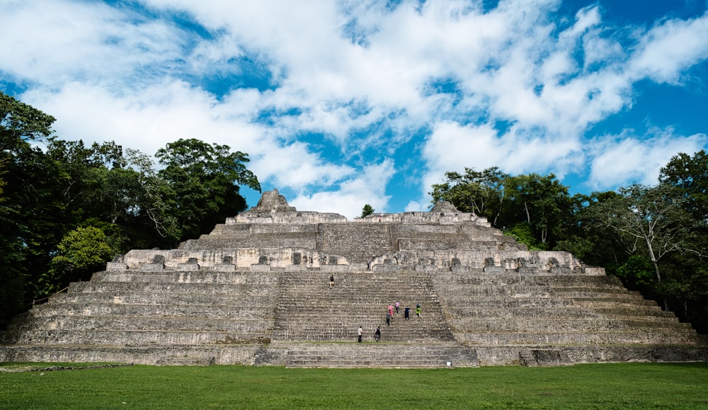 a group of people standing in front of a pyramid