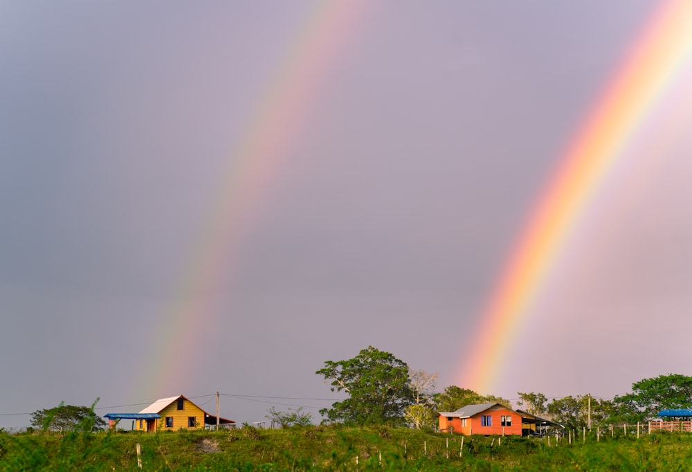 two rainbows are seen in the sky over a green field
