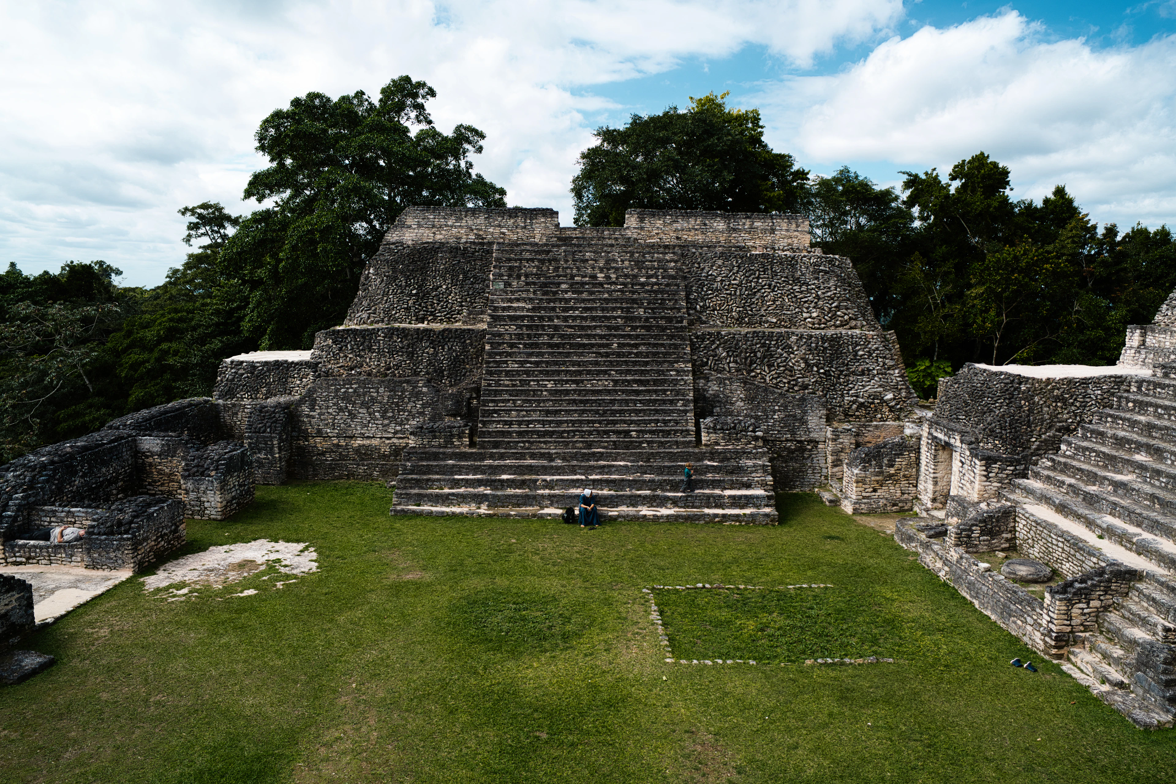 A stone Maya temple and plaza among jungle trees at Caracol, Belize