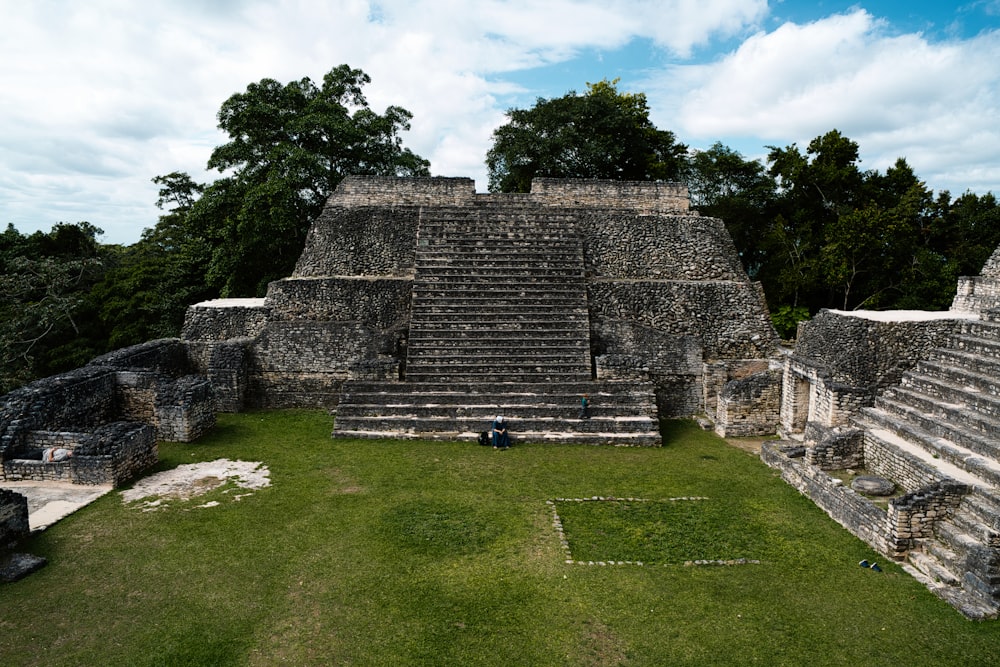 a large stone structure sitting on top of a lush green field