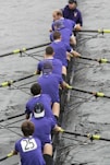 a group of men sitting on top of a boat in the water