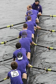 a group of men sitting on top of a boat in the water