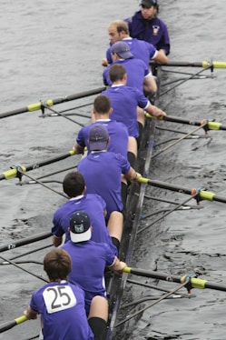 a group of men sitting on top of a boat in the water