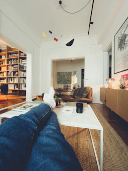 A bright, modern living room with a person relaxed, reading the ebook on a tablet.