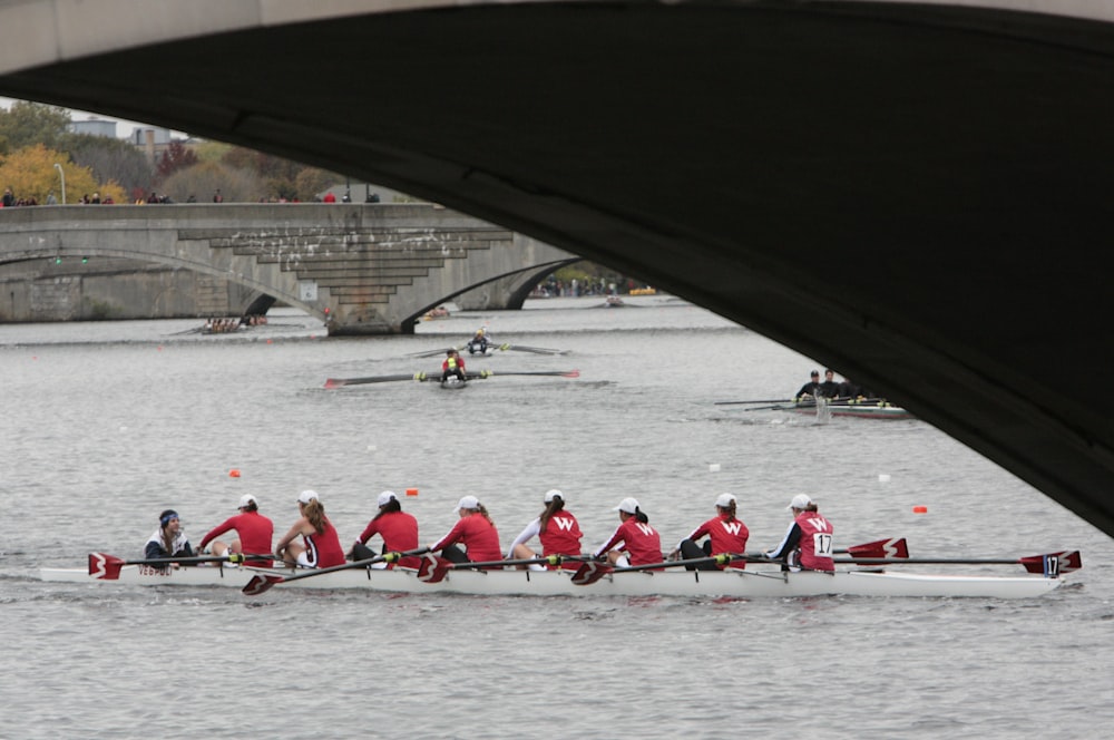 a group of people in red shirts rowing a boat