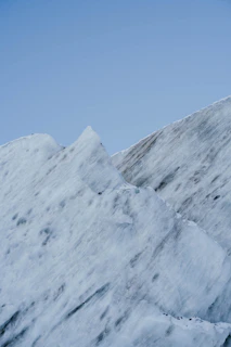 A glacial landscape with towering ice formations under a crisp, clear blue sky.