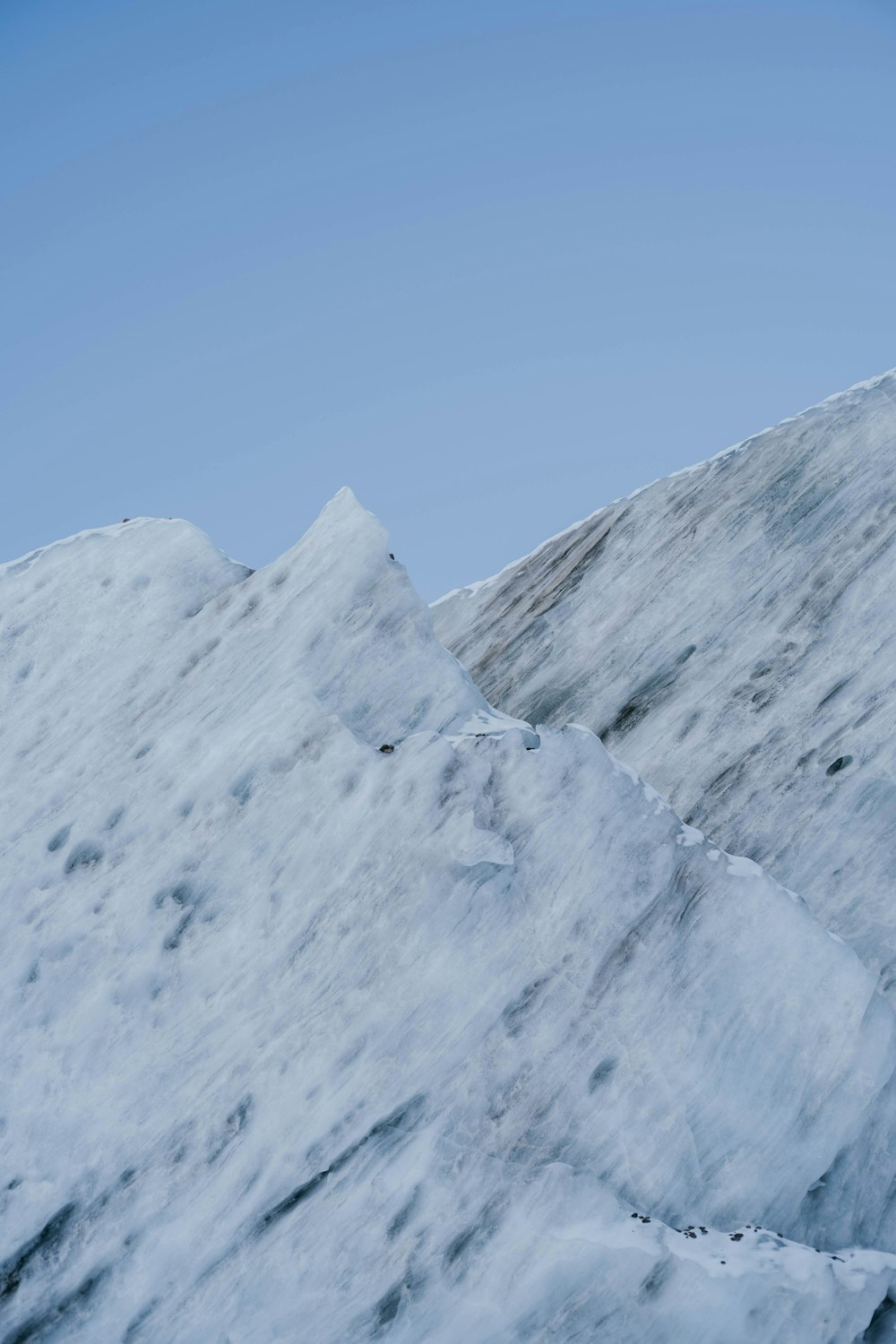 a man riding a snowboard down the side of a snow covered slope