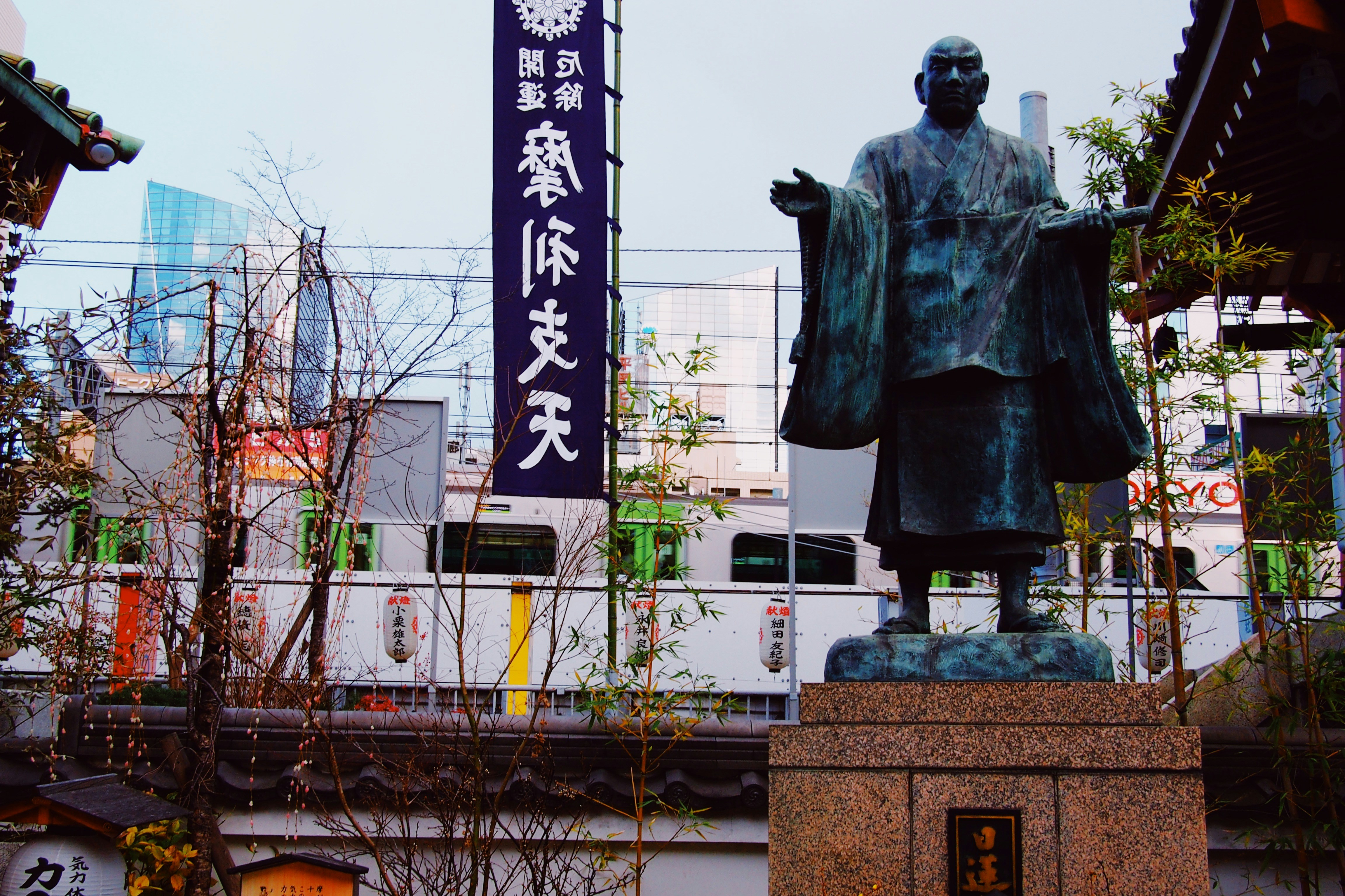 a statue of a man in a kimono in front of a building