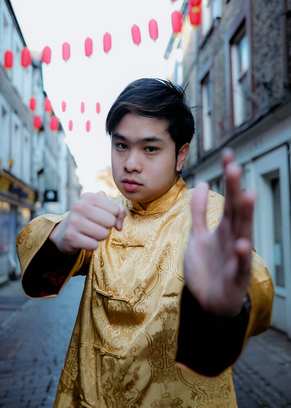 a young man dressed in a golden outfit standing on a street