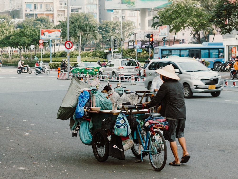 a person pushing a bike with a cart on the back of it