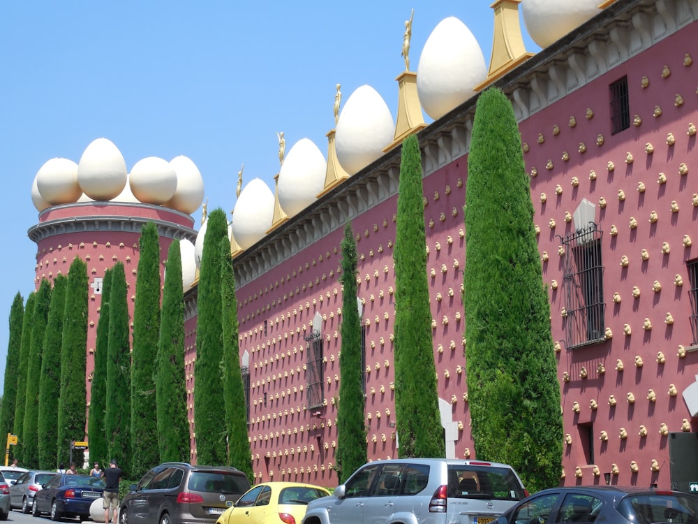 a row of trees line the side of a building