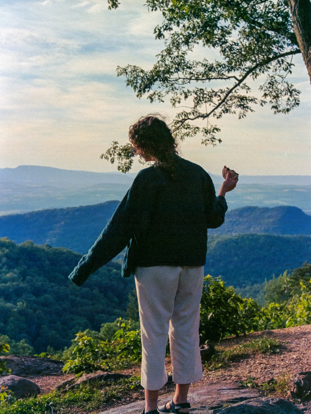 a woman standing on top of a mountain